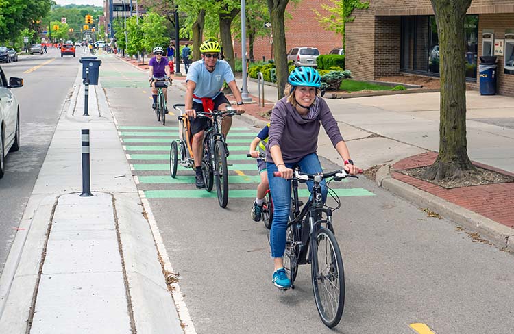 People biking in a dedicated bike lane in downtown Ann Arbor, Michigan